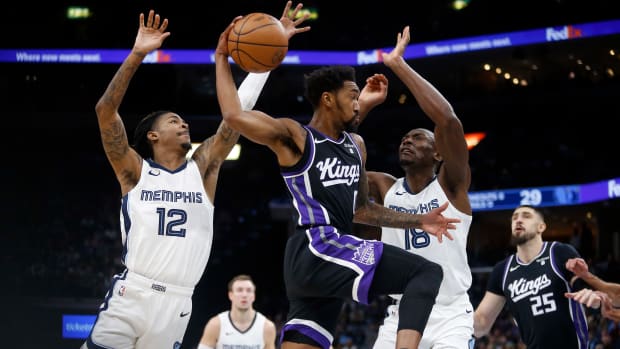 Dec 31, 2023; Memphis, Tennessee, USA; Sacramento Kings guard Malik Monk (0) passes the ball as Memphis Grizzlies guard Ja Morant (12) and center Bismack Biyombo (18) defends during the first half at FedExForum. Mandatory Credit: Petre Thomas-USA TODAY Sports